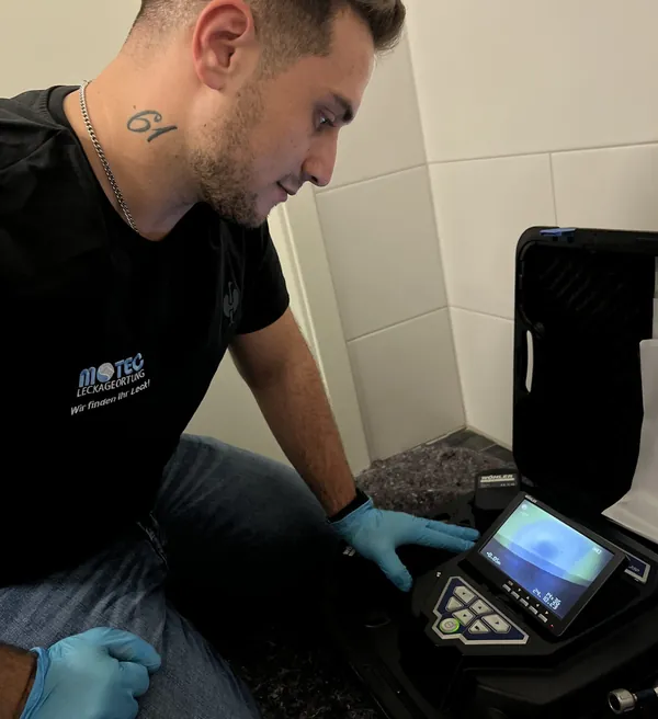 Techniker untersucht eine Leitung nach einem Rohrbruch